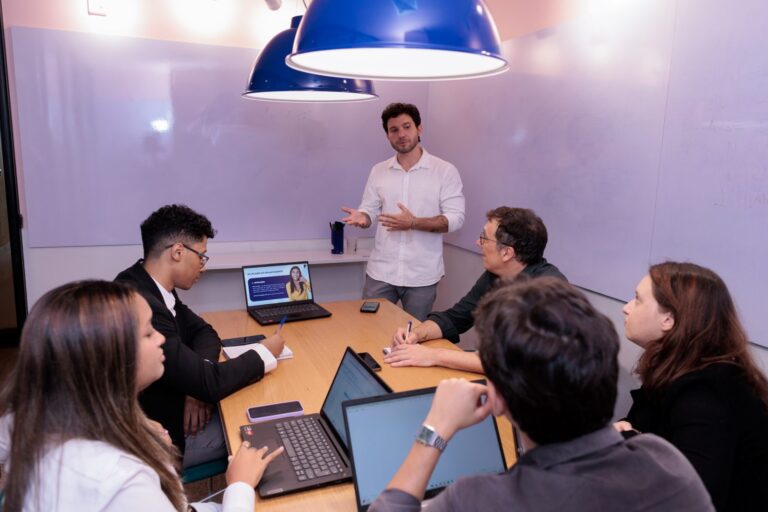 Turma in company numa sala de reunião, com o professor em pé conduzindo